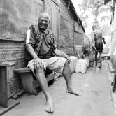 Portrait de Robert Pére chez lui, là ou il soigne. Ils sont, lui et son fils, les derniers de leur famille à avoir le Don. Il travaille uniquement avec sa salive : il crache sur les brulures. Les gens viennent de Tana pour se faire soigner. Le don se transmet par l’ ingération d’un foie de boeuf sur laquelle il aura craché et il faut suivre les fay ( pas de cochon, chévre, anguille) Avant il fallait tuer un Zébu et prendre son foie,