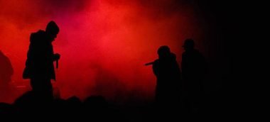 hip hop concert with rapper on stage. red enlightened fog in the background. silhouette of three rappers. little bit of noise in the fog due to high iso