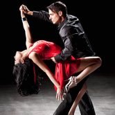 An attractive hispanic couple dancing the tango in a dance performance or competition.